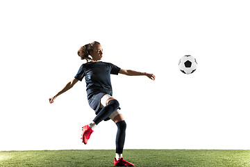 Image showing Female soccer player kicking ball isolated over white background