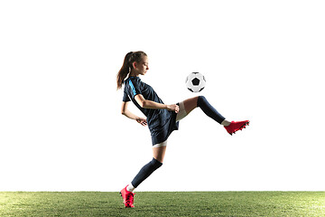 Image showing Female soccer player kicking ball isolated over white background