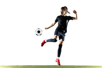 Image showing Female soccer player kicking ball isolated over white background