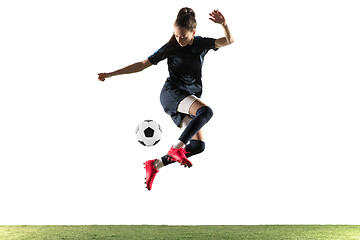 Image showing Female soccer player kicking ball isolated over white background