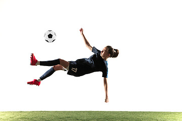 Image showing Female soccer player kicking ball isolated over white background