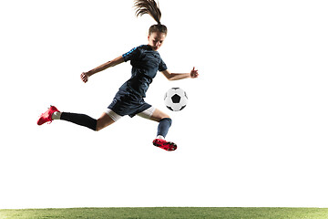 Image showing Female soccer player kicking ball isolated over white background