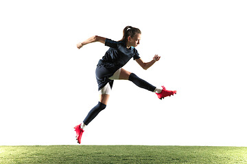 Image showing Female soccer player kicking ball isolated over white background