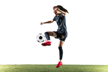 Image showing Female soccer player kicking ball isolated over white background