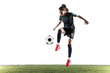 Image showing Female soccer player kicking ball isolated over white background