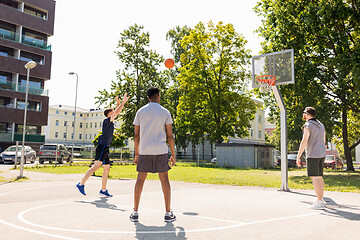 Image showing group of male friends playing street basketball