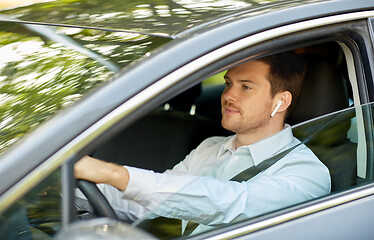 Image showing man or driver with wireless earphones driving car