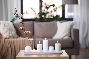 Image showing burning white candles on table at cozy home