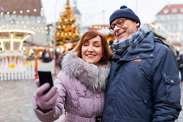 Image showing senior couple taking selfie at christmas market