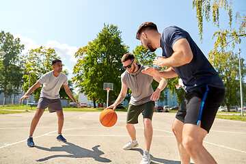 Image showing group of male friends playing street basketball