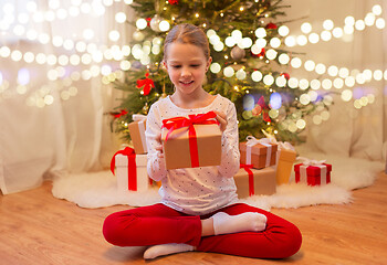 Image showing smiling girl with christmas gift at home