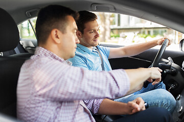 Image showing car driving school instructor teaching male driver