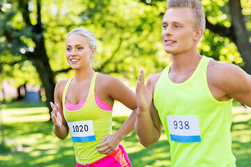 Image showing happy couple of sportsmen racing wit badge numbers