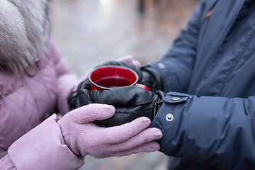 Image showing couple\'s hands holding mulled wine on christmas