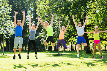 Image showing group of happy friends jumping high at park