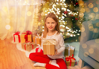 Image showing smiling girl with christmas gift at home