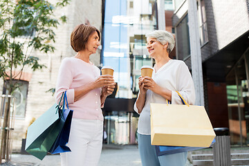Image showing senior women with shopping bags and coffee in city