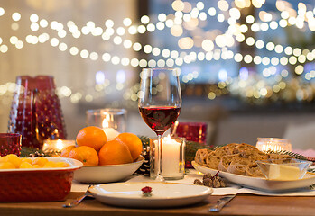 Image showing glass of red wine and food on christmas table