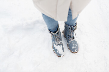 Image showing female feet in winter shoes on snow from top