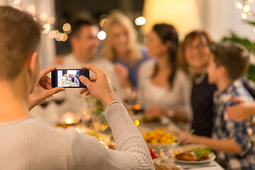 Image showing man taking picture of family at dinner party