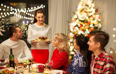 Image showing happy friends having christmas dinner at home