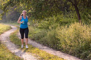 Image showing woman jogging along a country road