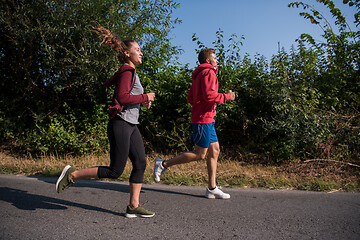 Image showing young couple jogging along a country road