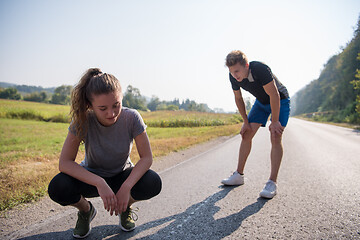 Image showing young couple warming up and stretching on a country road