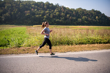 Image showing woman jogging along a country road