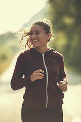 Image showing woman jogging along a country road