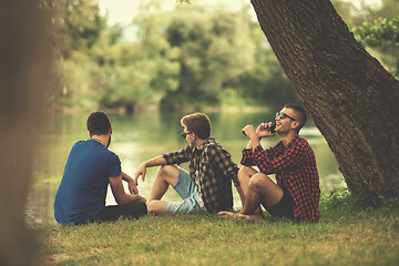 Image showing men sitting on the bank of the river