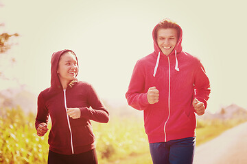 Image showing young couple jogging along a country road