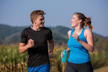 Image showing young couple jogging along a country road