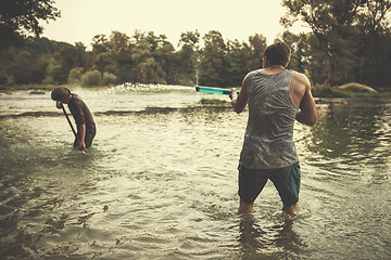 Image showing young men having fun with water guns