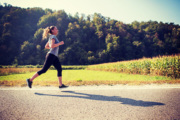 Image showing woman jogging along a country road