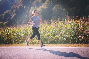 Image showing woman jogging along a country road