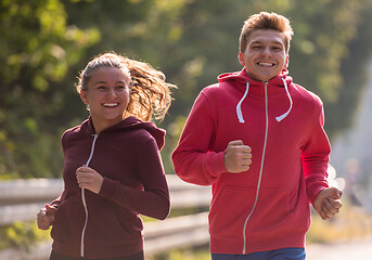 Image showing young couple jogging along a country road