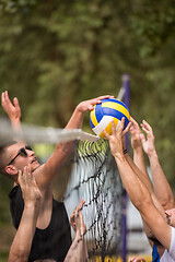 Image showing group of young friends playing Beach volleyball
