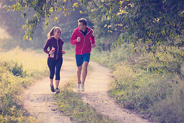 Image showing young couple jogging along a country road