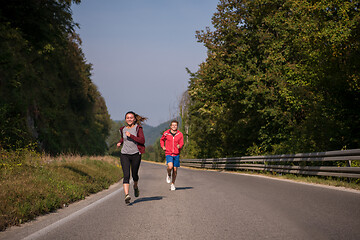 Image showing young couple jogging along a country road