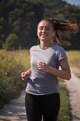 Image showing woman jogging along a country road