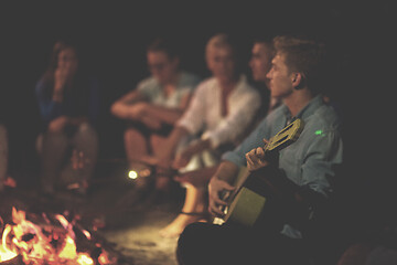 Image showing young friends relaxing around campfire