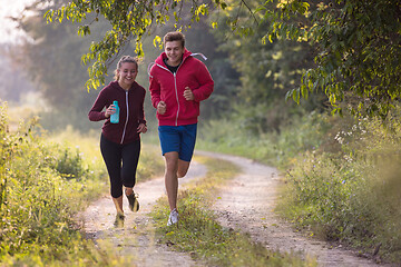 Image showing young couple jogging along a country road