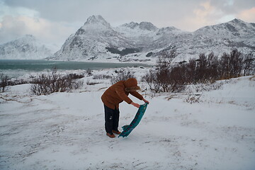 Image showing Muslim traveler praying in cold snowy winter day