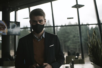 Image showing business man wearing protective face mask at luxury office