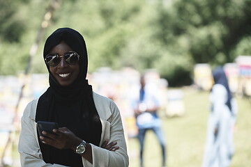 Image showing african woman using smartphone wearing traditional islamic clothes