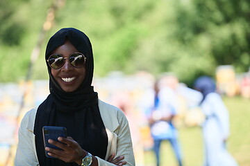 Image showing african woman using smartphone wearing traditional islamic clothes