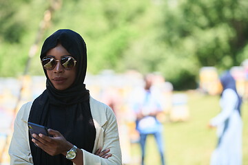 Image showing african woman using smartphone wearing traditional islamic clothes