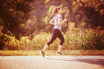 Image showing woman jogging along a country road