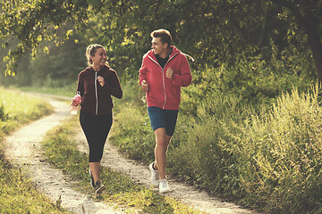 Image showing young couple jogging along a country road